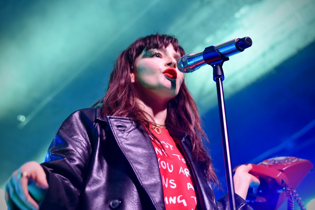 Lauren Mayberry singing using phone prop at her show in Nashville 