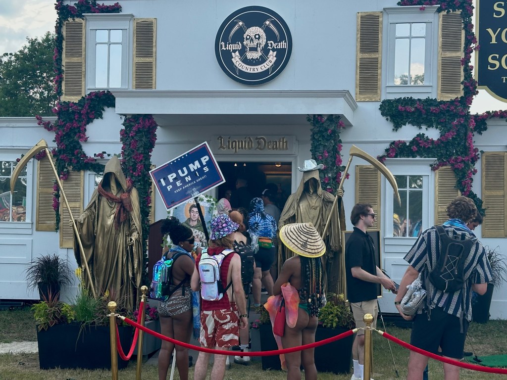 Festival attendees wait to enter the Liquid Death Country Club at Bonnaroo 2025