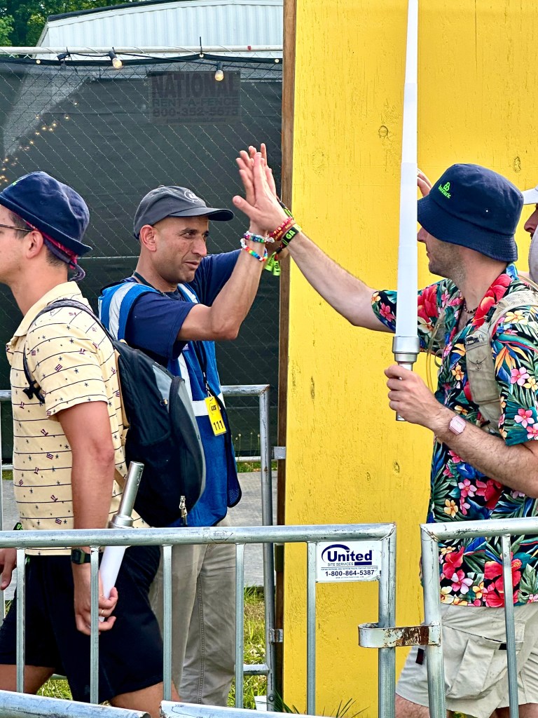 High fives as fans enter the What Stage pit at Bonnaroo 2025