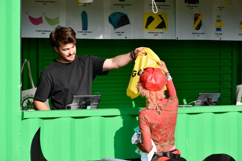 Festival attendee purchasing Golf Wang brand merchandise at Hinterland Music Festival