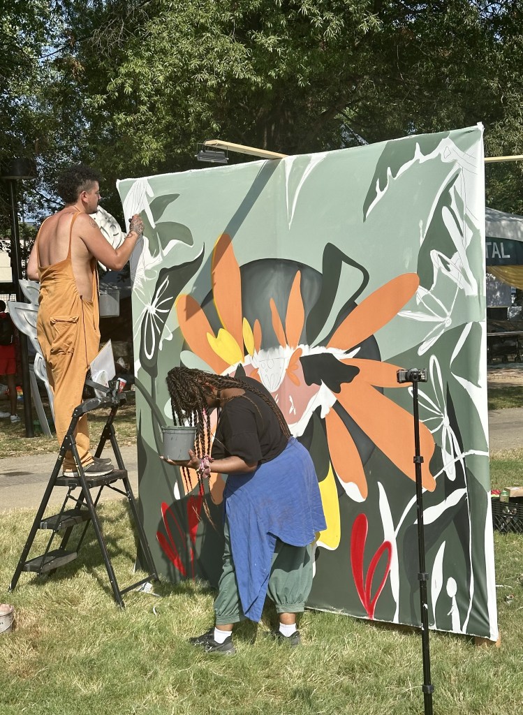 Artists working on a painting at Deep Tropics 2025